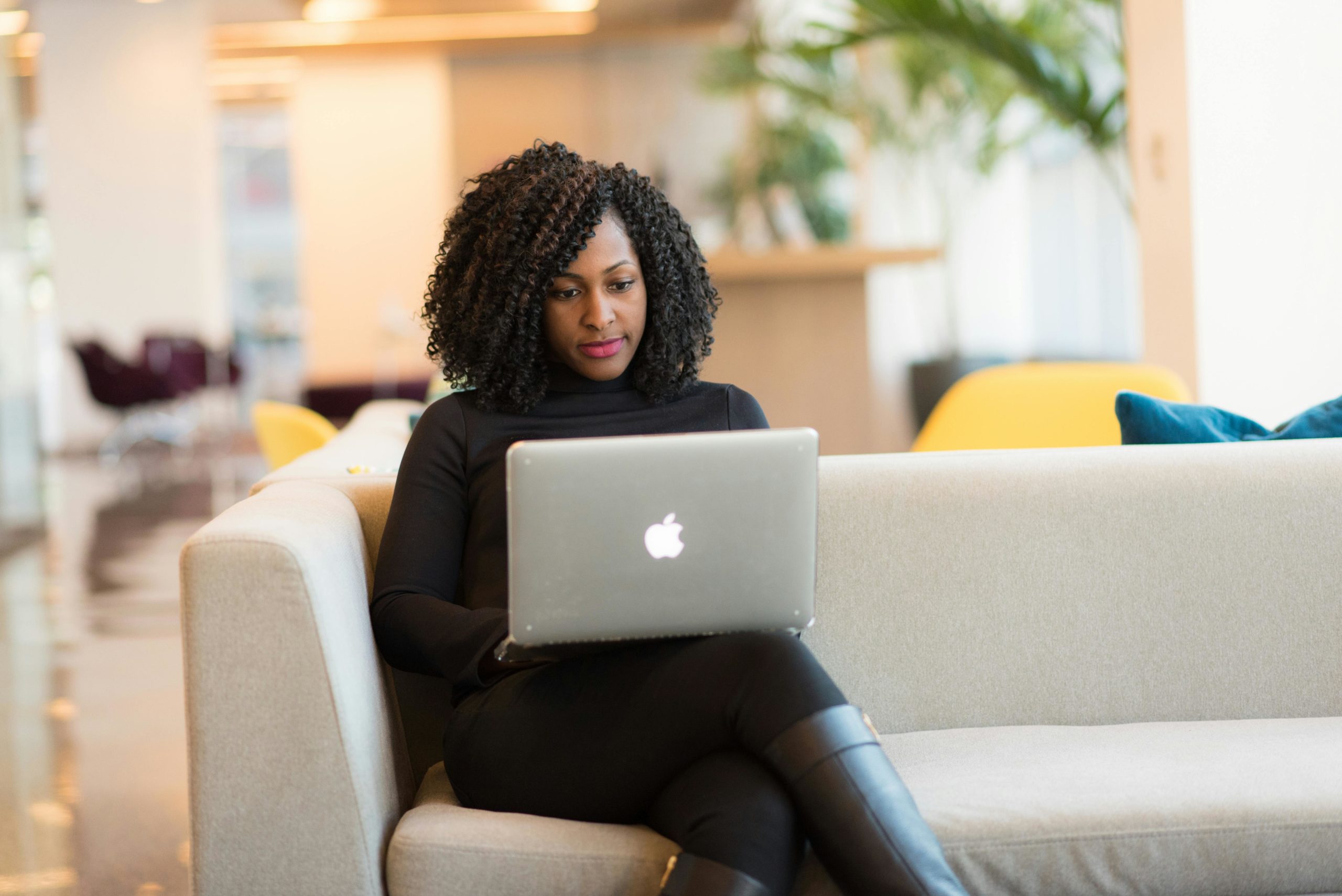 pexels-photo-1181414-1181414 An African American woman working remotely on a laptop in a modern indoor setting.